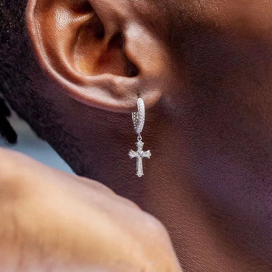 Silver-tone cross drop earring with a stone-covered hoop and cross pendant in a tight ear close-up