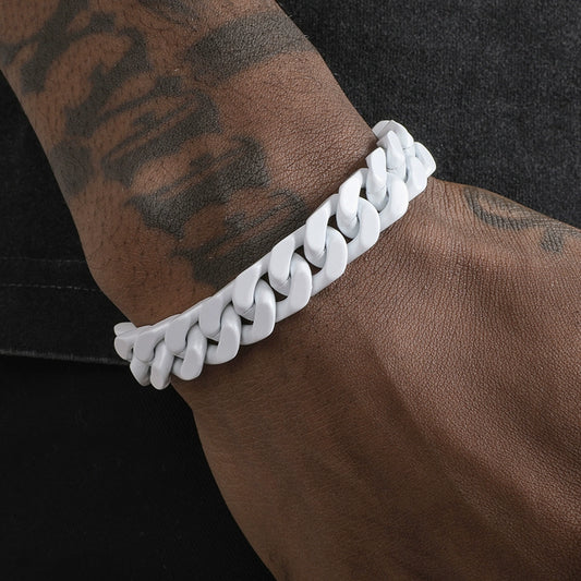 A white Cuban link bracelet worn on a tattooed wrist, close-up side view