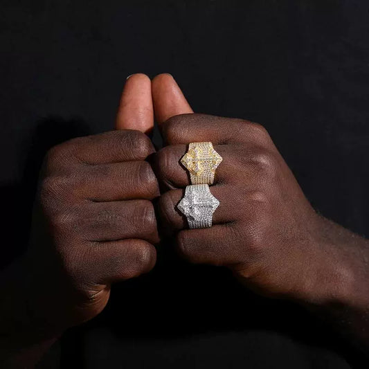 Two rings, one gold-tone and one silver-tone, with geometric stone-covered faces stacked on one finger