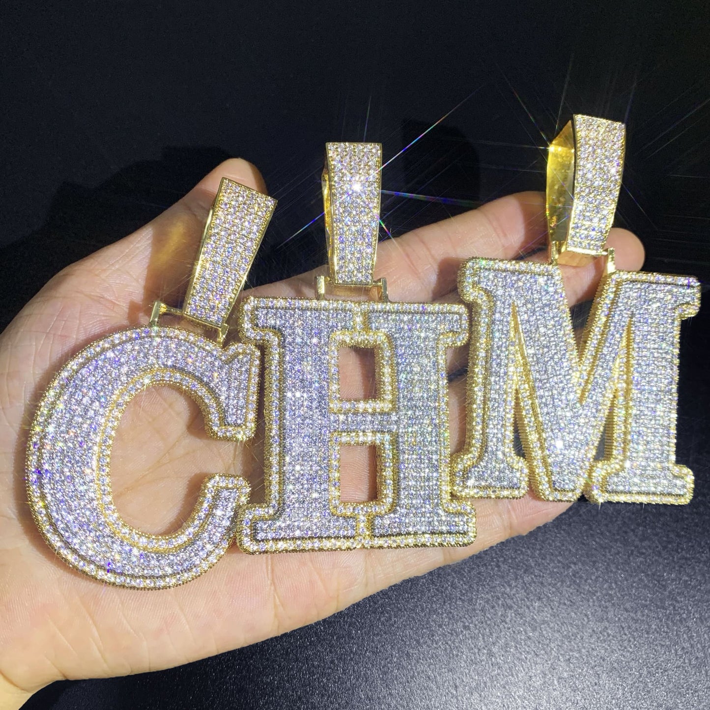 IceGrind gold initial pendant collection showing letters C, H, and M. Custom iced-out gold initial pendant necklaces.