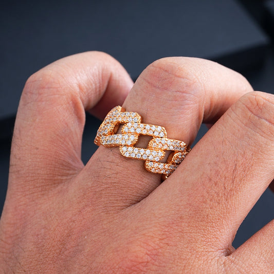 Rose-gold-tone chain-link ring with stone-covered links worn on a hand against a dark background