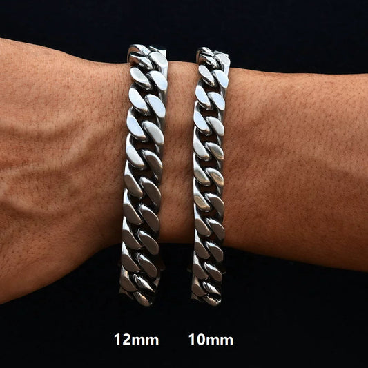 Two silver-tone Cuban link bracelets of different widths stacked on a wrist