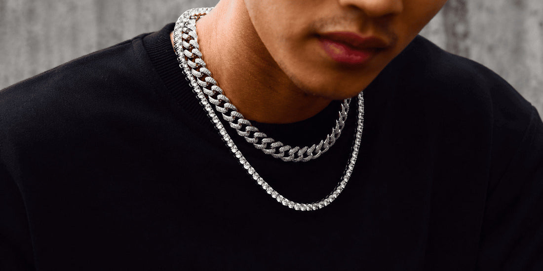 Man wearing a silver Cuban link chain layered with a tennis chain for a men’s jewelry style comparison.