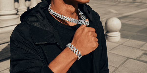 Man wearing a moissanite Cuban link chain and matching bracelet outdoors in bright sunlight for everyday wear.