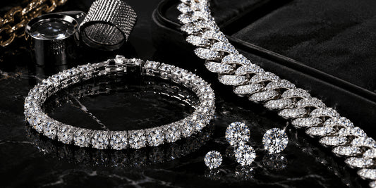 IceGrind moissanite tennis bracelet and iced-out moissanite chain on black marble, highlighting high-quality moissanite fire, stone clarity, and premium hip hop jewelry craftsmanship.