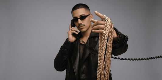 An intricate iced out Cuban link chain is worn layered with a classic gold plain Cuban chain. The detailed design is a staple for Cuban link chain men's style. Explore mens gold chain options for an iconic, customized look at IceGrind.