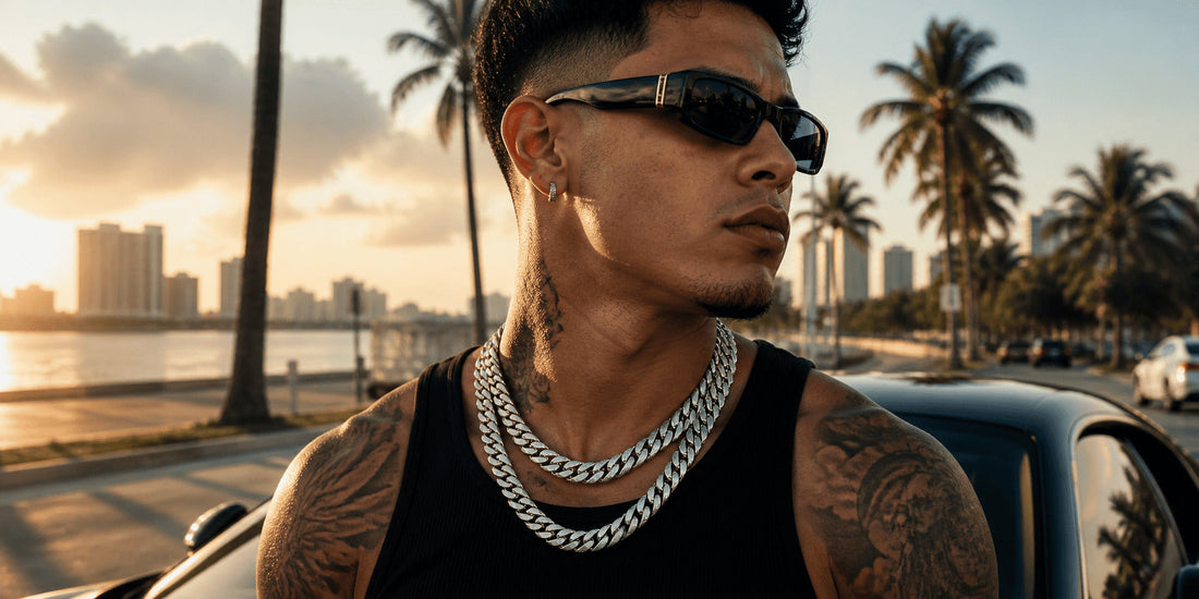 IceGrind Latino male model wearing two silver miami cuban link chains on a Miami coastal road at sunset, featuring modern hip hop jewelry styling and urban streetwear aesthetics.