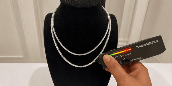 6MM Moissanite Tennis Chain being tested with a diamond tester on a black jewelry display bust.