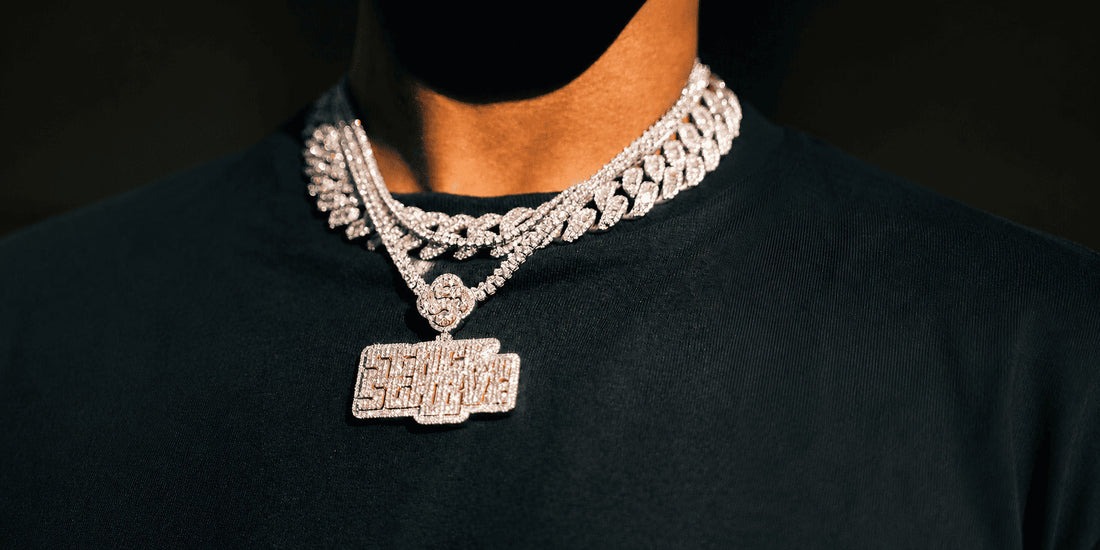 Man wearing an iced Cuban link chain with a pendant over a black shirt, showing how to style a bold chain without looking overdone.