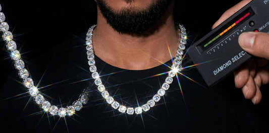 A close-up of a man wearing lcegrind moissanite tennis chains, with one linkbeing tested by a Diamond Select device, showing a pass, all glowing with fire.