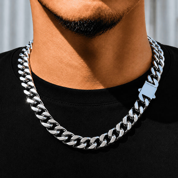 12MM white gold Miami Cuban link chain worn around the neck on a model in a neutral blurred scene