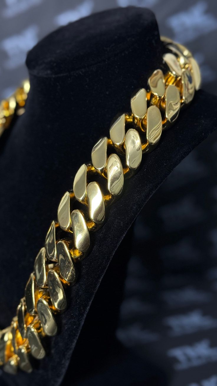 20MM gold Miami Cuban link chain draped over a stand with its box clasp visible