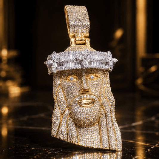 Close-up of a yellow gold Iced Out Baguette Crown Jesus Pendant featuring intricate cubic zirconia detailing on a dark reflective surface.