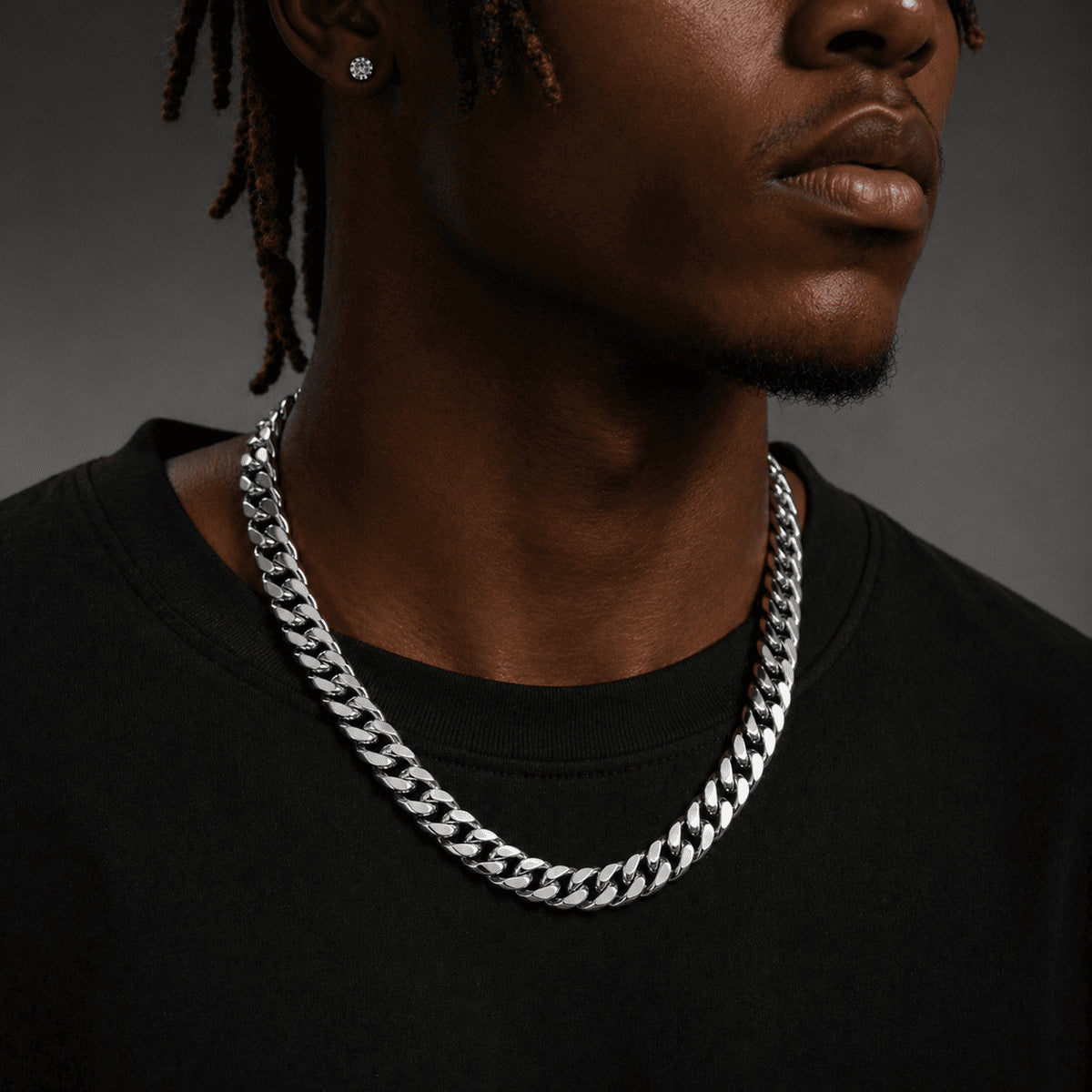 10MM white gold Miami Cuban link chain worn around the neck on a model for fit and style against a neutral gray background