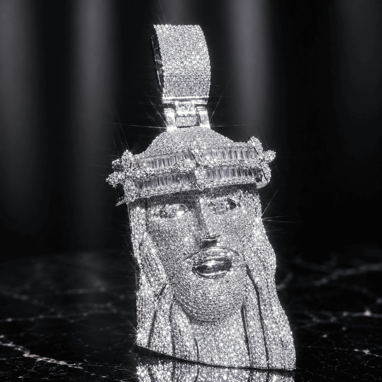 Brilliant silver-tone titanium steel Iced Out Baguette Crown Jesus Piece resting on a sleek black marble background.