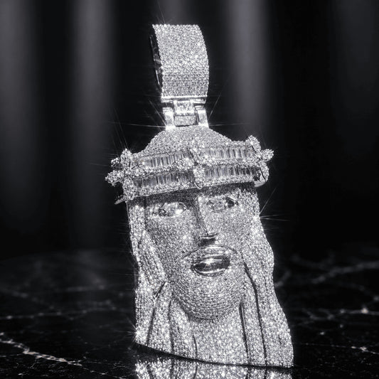 Brilliant silver-tone titanium steel Iced Out Baguette Crown Jesus Piece resting on a sleek black marble background.