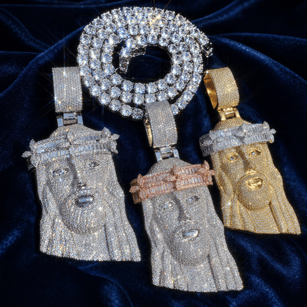 Collection of three Iced Out Baguette Crown Jesus Pendants in multiple color finishes with a matching chain on dark blue velvet.