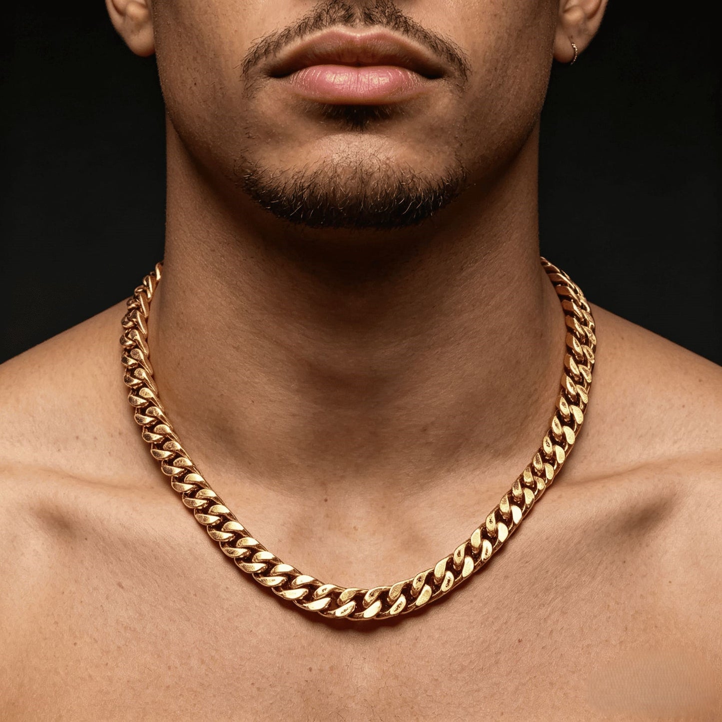 12MM 18k gold cross Cuban link chain worn around the neck against a dark background