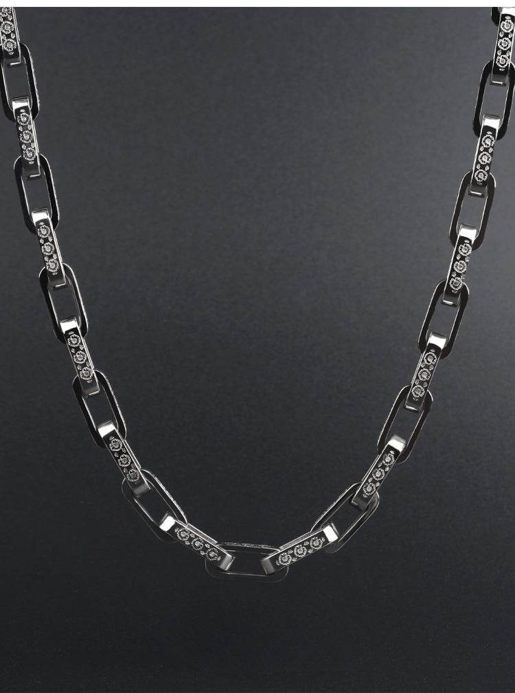Curved 10MM white gold mariner link chain laid against a dark background