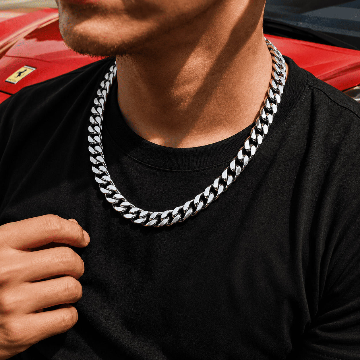 A man posing in front of a red sports car wearing the IceGrind 12MM Miami Cuban Link Chain, showcasing how the jewelry catches the natural sunlight.
