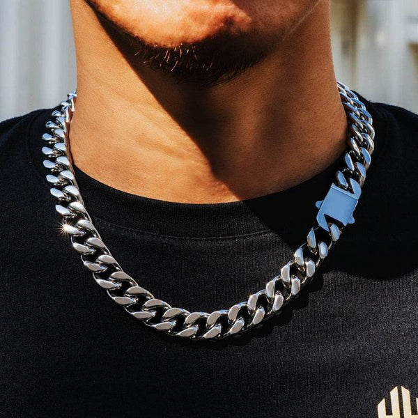 white gold Miami Cuban link chain worn around the neck in a neutral outdoor setting