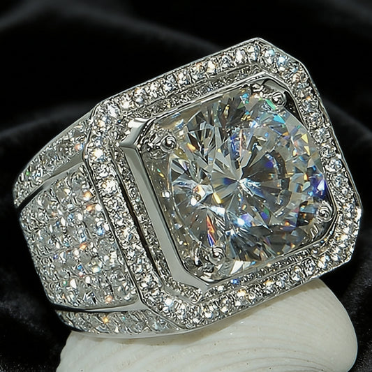 Silver-tone ring with a clear center stone, square frame and wide stone-covered band, displayed upright
