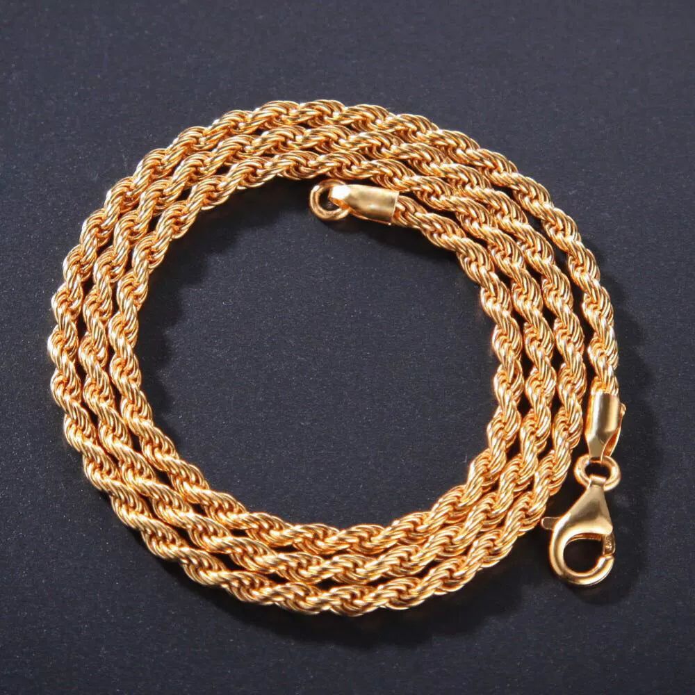Coiled 3MM gold rope chain on a dark textured surface with its lobster clasp visible
