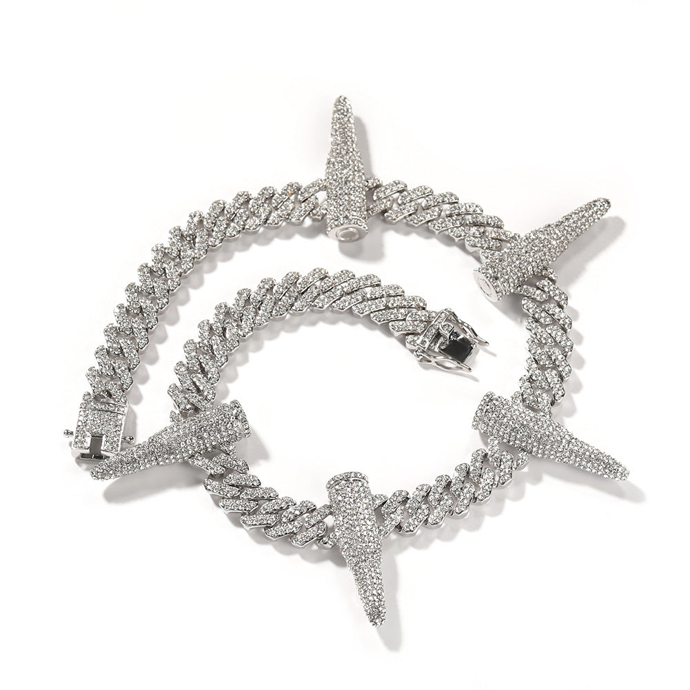 Coiled 12MM white gold Cuban link chain with iced out bullet links against a white background with its clasp visible