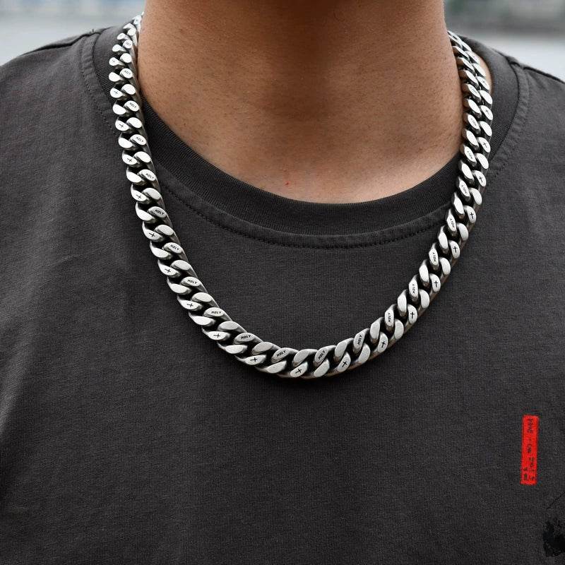 white gold Miami Cuban link chain worn around the neck for fit and style over a dark shirt