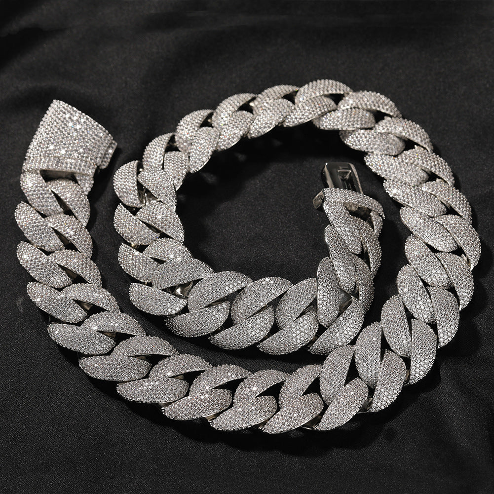 Coiled 24MM white gold Cuban link chain on dark fabric showing iced link sparkle with its box clasp visible