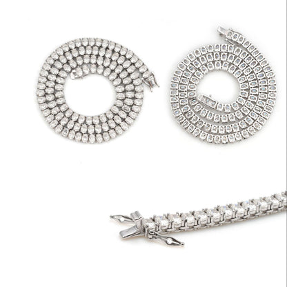 Coiled 7MM moissanite tennis chain against a white background showing its wide link structure with its lobster clasp visible