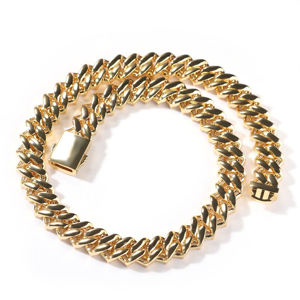Coiled 12MM 14k gold Cuban link chain against a white background showing its wide link structure with its box clasp visible