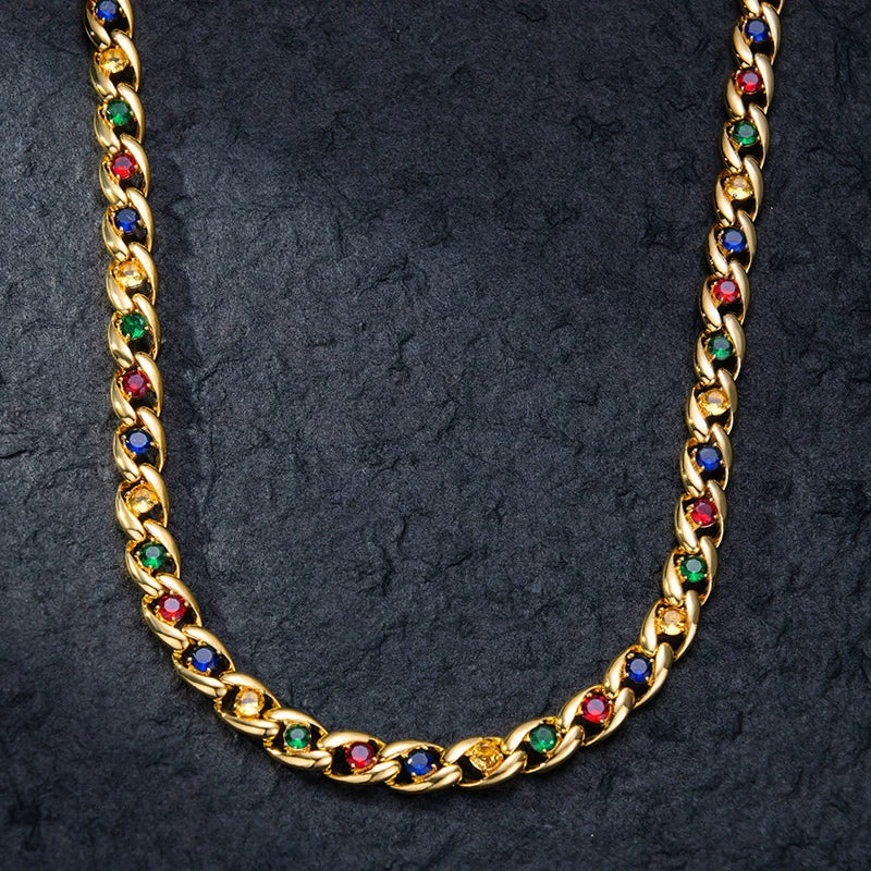 Curved 10MM gold Cuban link chain laid on a dark textured surface
