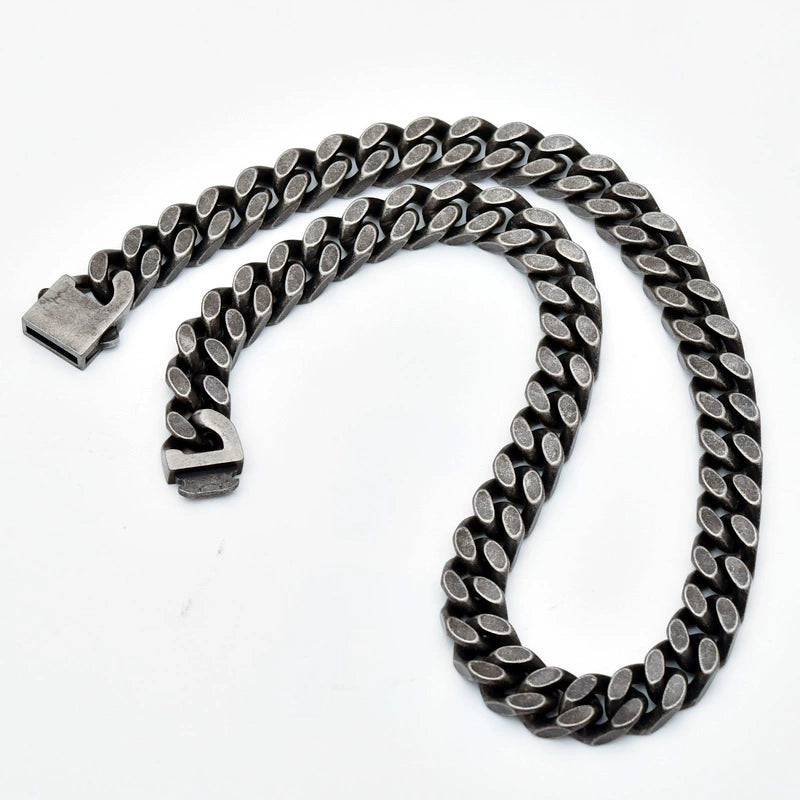 Coiled 12MM black Cuban link chain against a white background with its box clasp visible