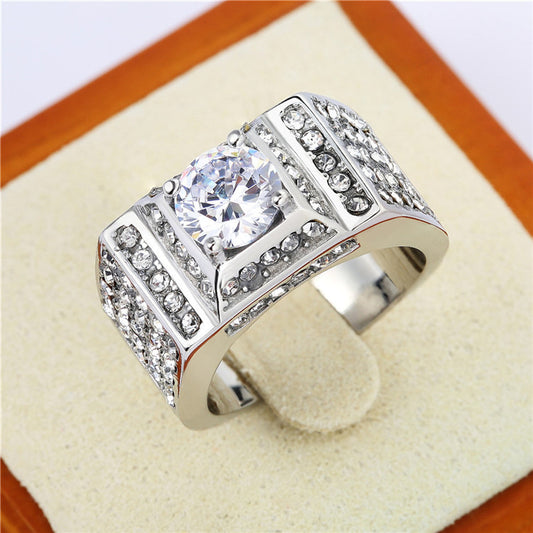 Silver-tone band ring with a round center stone and extensive clear stone coverage, displayed upright