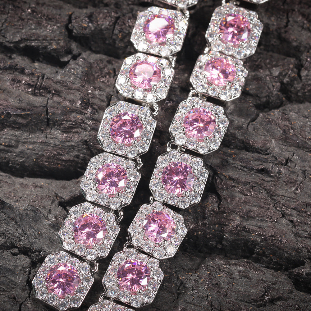 Close-up of 12MM pink tennis chain links laid flat on a dark textured surface