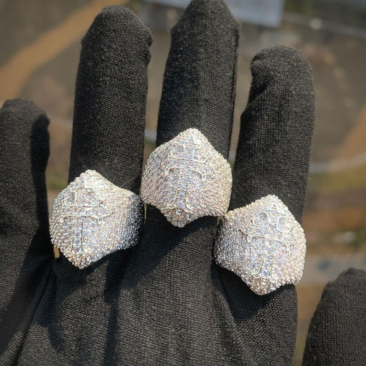 Three silver-tone cross rings with full stone coverage on a black glove