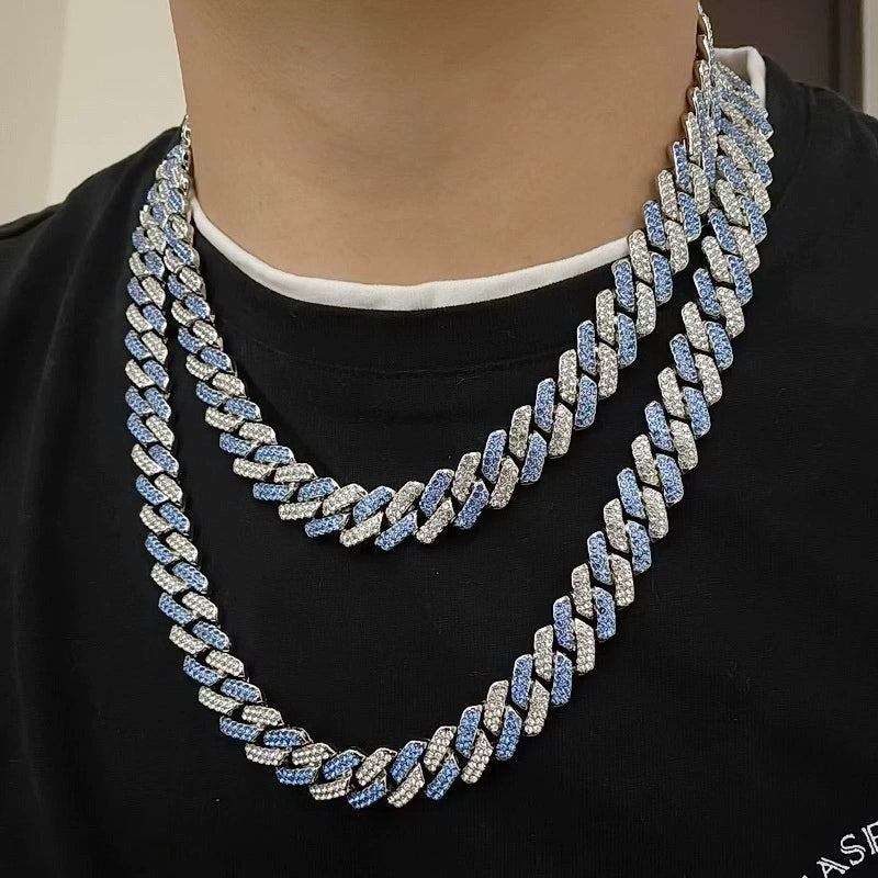 Layered 13MM white gold Cuban link chain worn around the neck against a neutral background