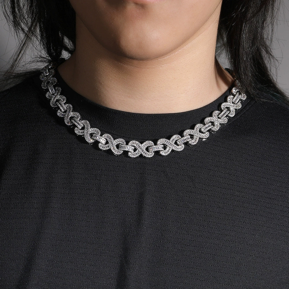 16MM white gold infinity link chain worn around the neck on a dark textured surface