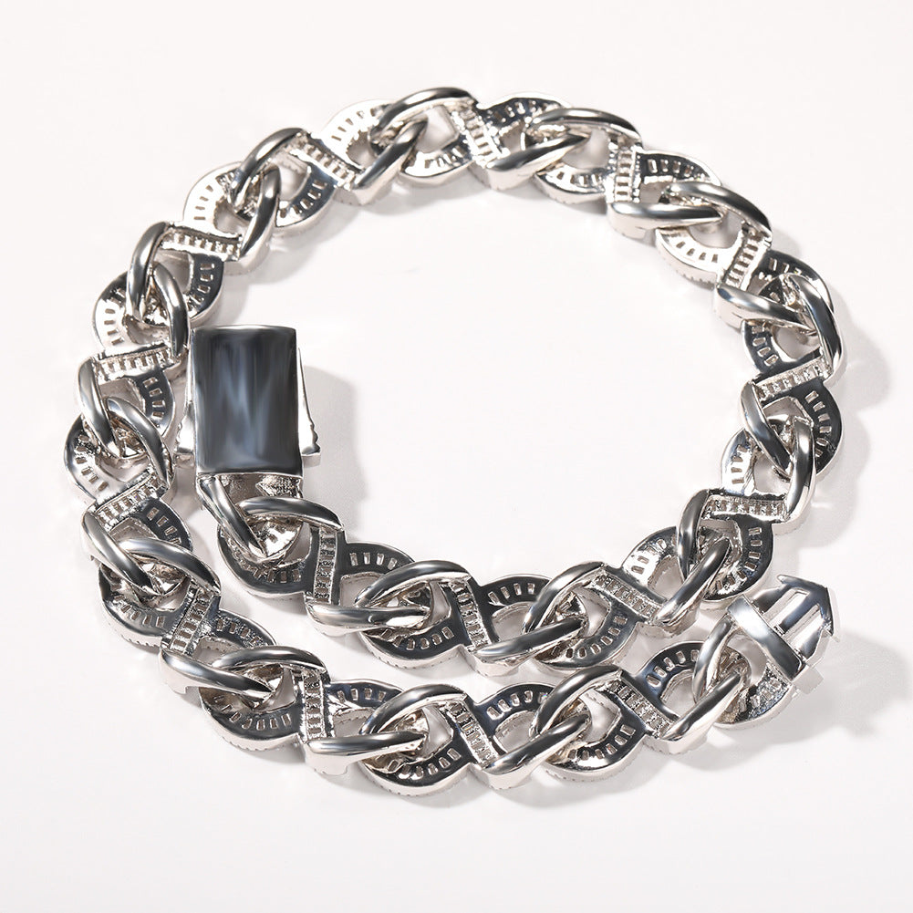Coiled Miami Cuban link chain against a white background showing its wide link structure with its box clasp visible