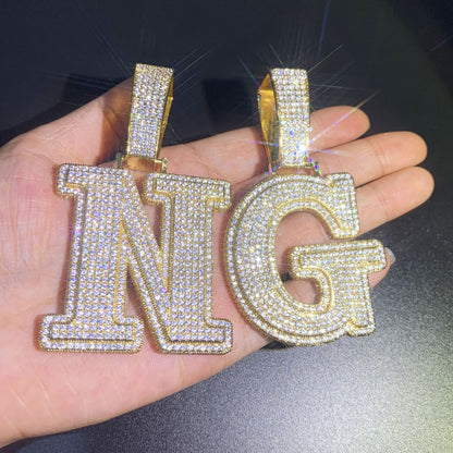 Custom initial pendant pairing by IceGrind. A large B pendant styled with a smaller H charm, both feature Flawless VVS simulated diamonds on an 18K gold-plated base.