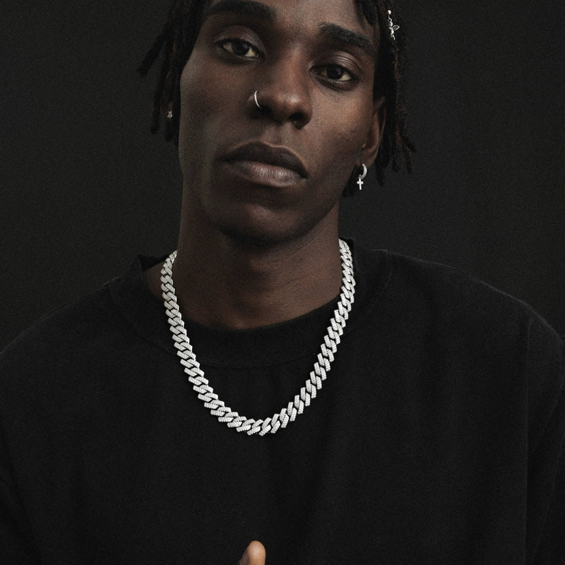 14MM white gold Cuban link chain worn around the neck on a model on a dark textured surface