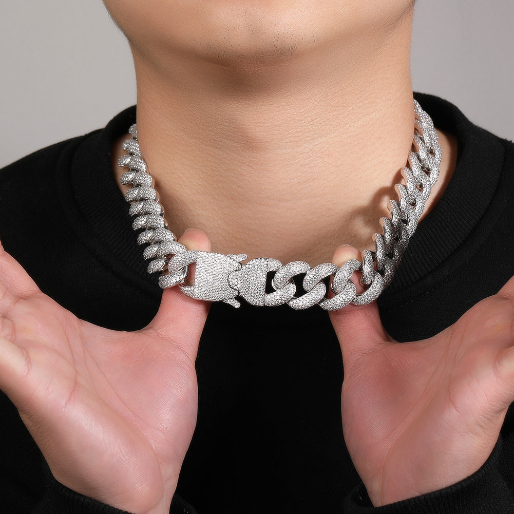 20MM white gold Cuban link chain worn around the neck on a model against a neutral background