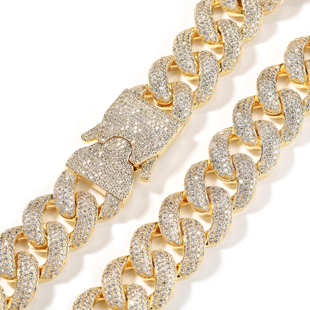 Coiled 20MM gold Cuban link chain against a white background showing clasp detail with its box clasp visible
