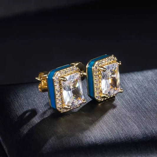 Pair of gold-tone rectangular stud earrings with clear center stones, aqua side accents, and stone halos