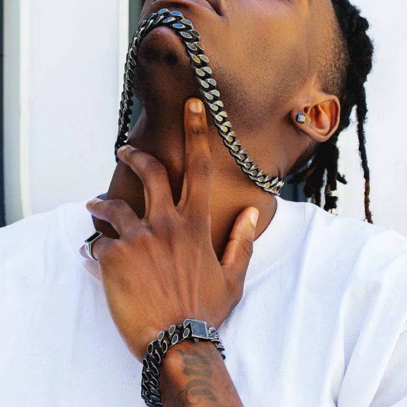 12MM black Cuban link chain worn around the neck with a matching bracelet visible on the wrist