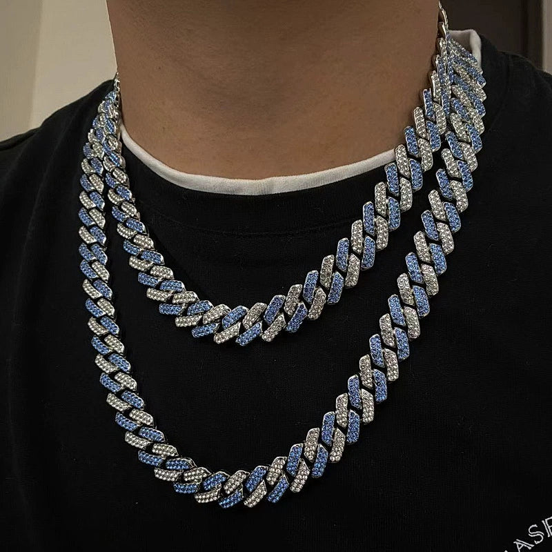Layered 13MM white gold Cuban link chain worn around the neck over a black shirt
