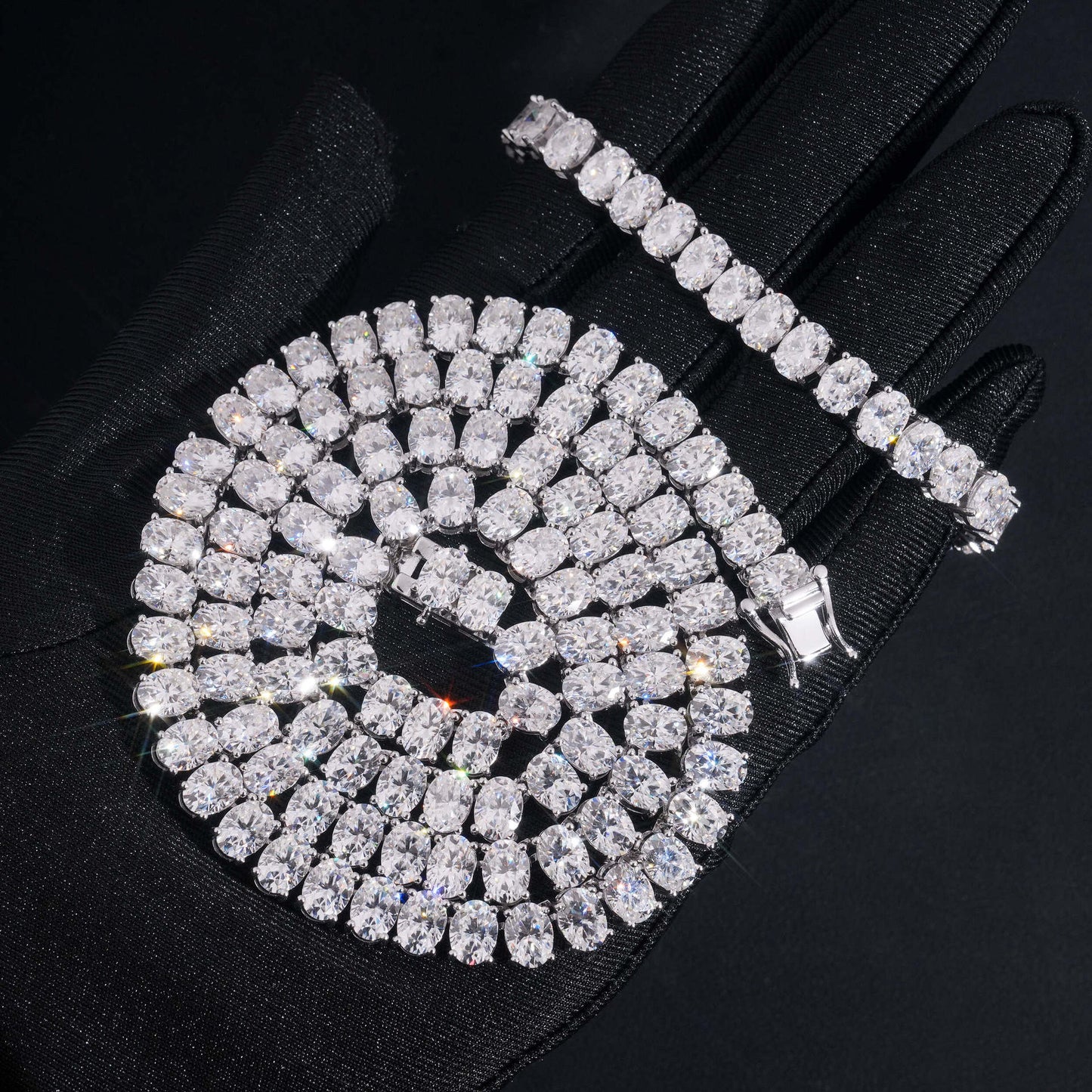 Coiled 7MM moissanite tennis chain showing its wide link structure with its lobster clasp visible