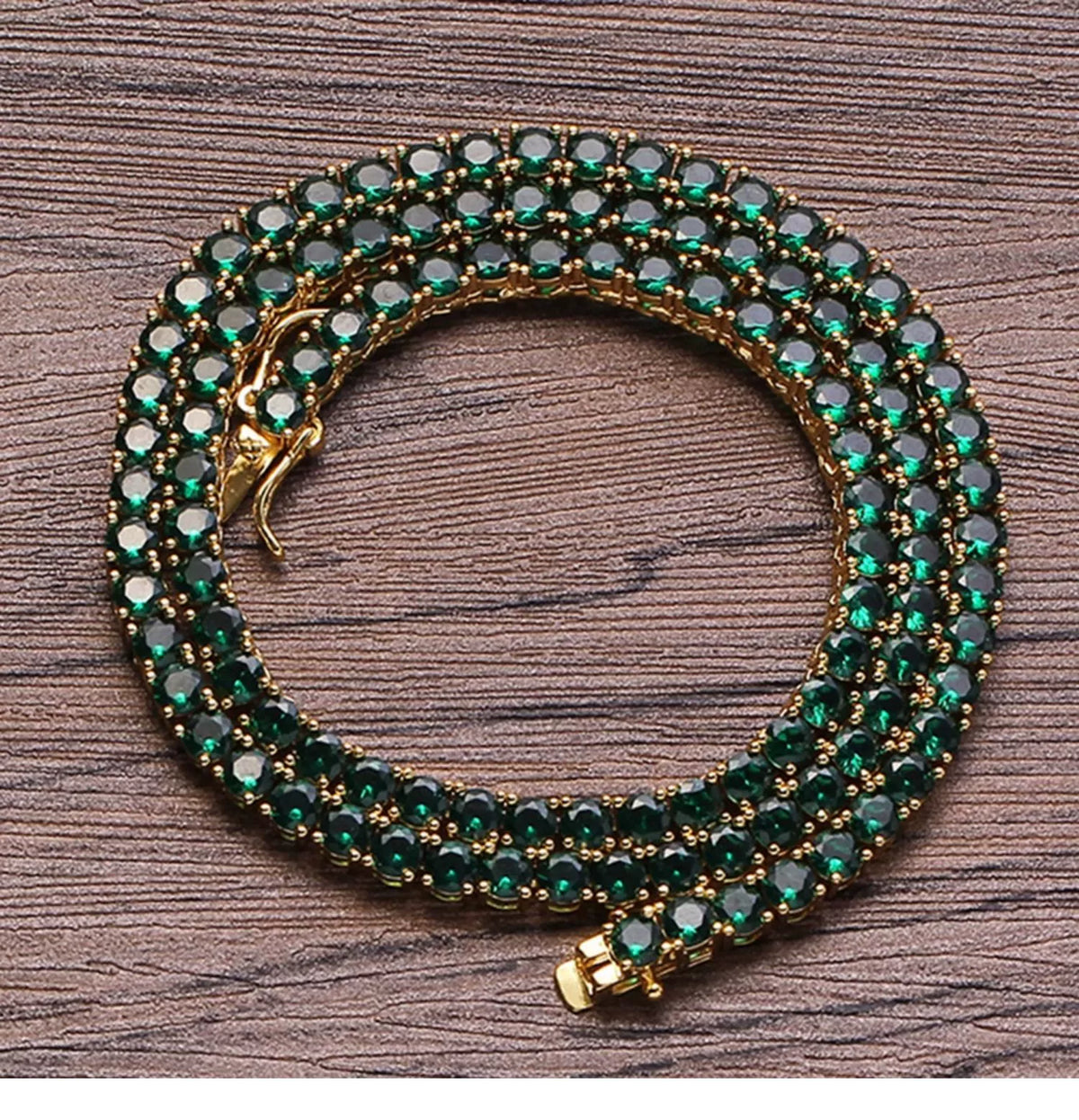 Coiled 4MM gold tennis chain on a wooden surface with its box clasp visible