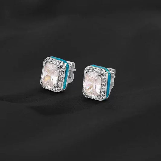 Pair of silver-tone rectangular halo stud earrings with clear center stones and aqua side accents